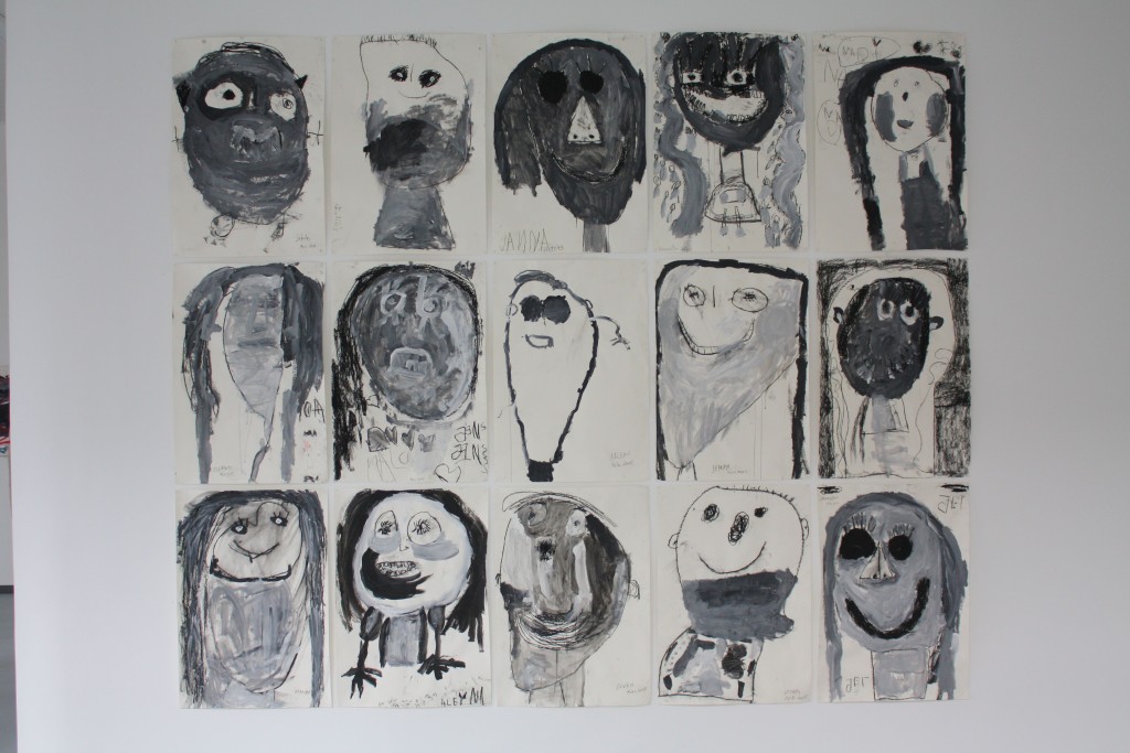 Die Bildinstallation zusammengesetzt aus einzelnen Kohlezeichnungen der Kinder, an einer der Galeriewände.