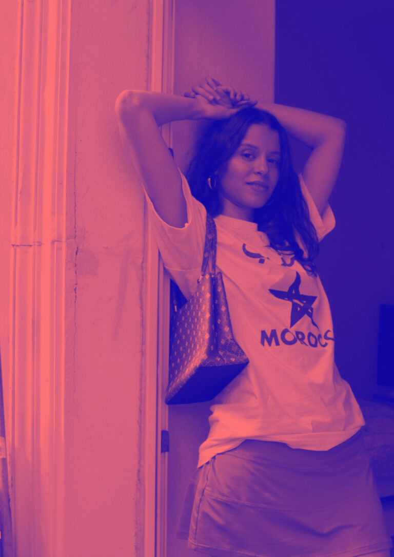 Foto von Yousra wie an einer Wand lehnt